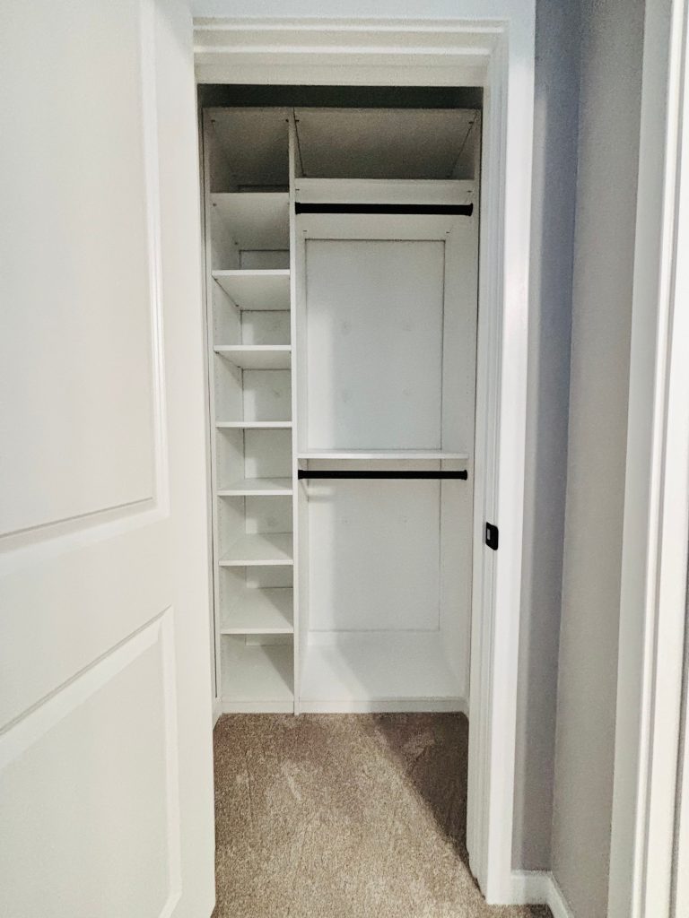 Custom reach-in closet with black hardware in Zephyrhills, Florida.