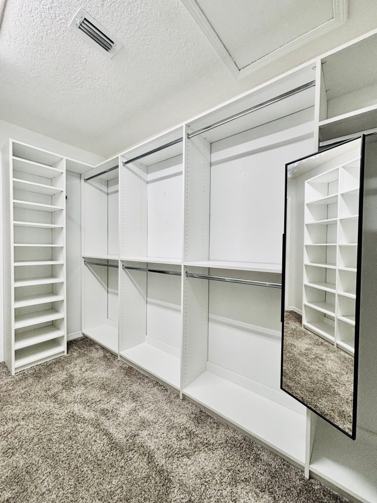 Custom walk-in closet with chrome hardware in Land O' Lakes, Florida.