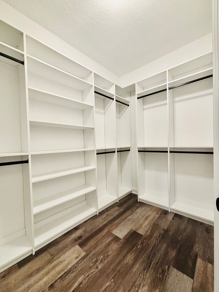 Custom walk-in closet with black hardware in Trinity, Florida.