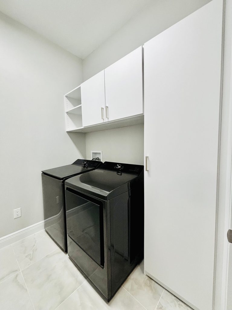 Custom laundry room with doors, drawers, matte colors, nickel hardware in Lithia, Florida.