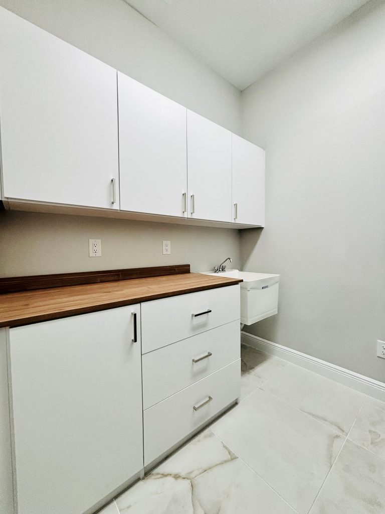 Custom laundry room with doors, drawers, matte colors, nickel hardware in Lithia, Florida.