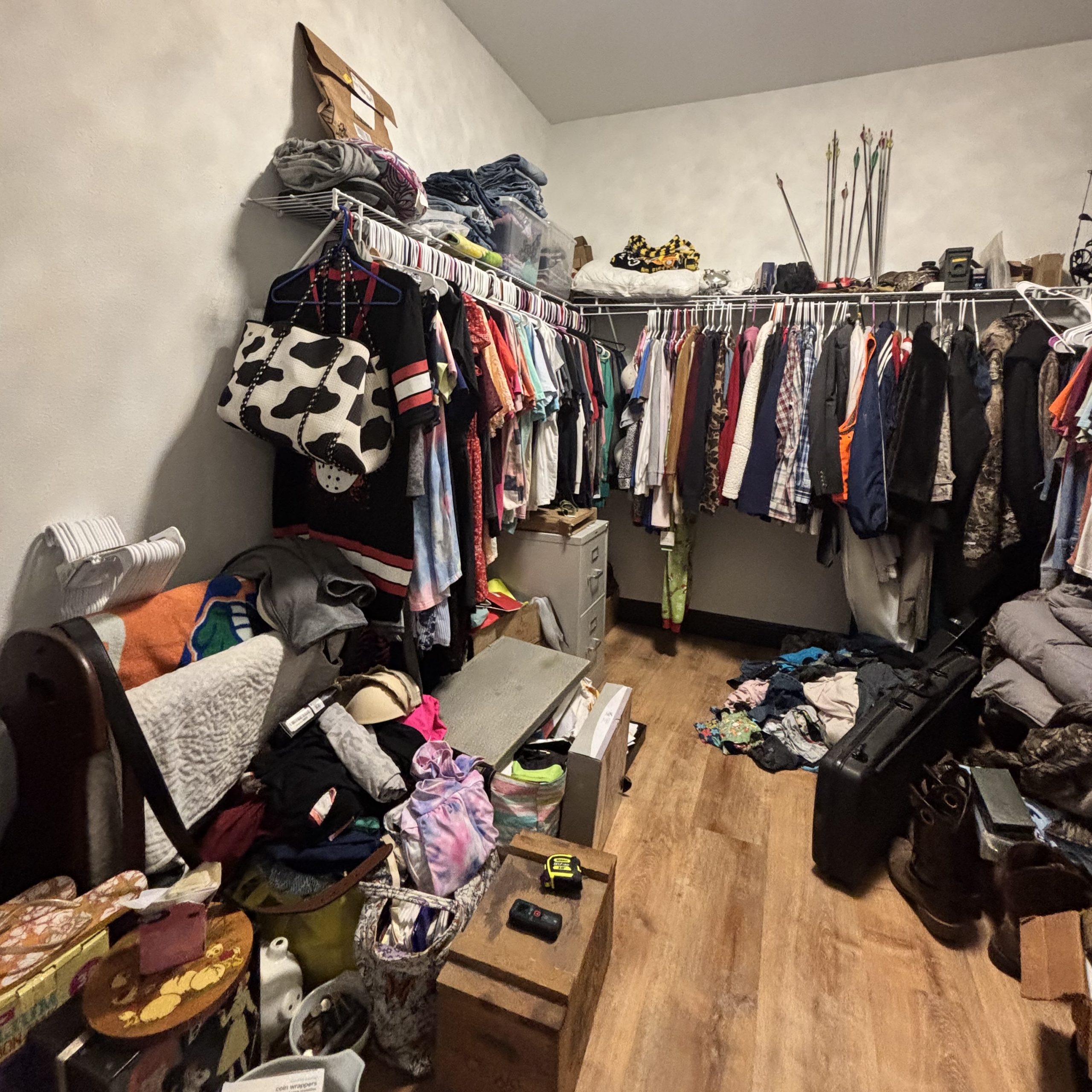Walk-in closet with cluttered shelves and piles