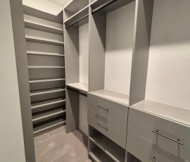 Custom walk-in closet with drawers, matte colors, slate hardware in San Antonio, Florida.