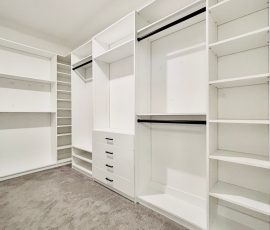 Custom walk-in closet with drawers, black hardware in Wesley Chapel, Florida.