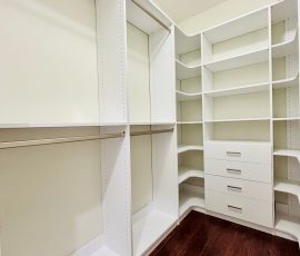 Custom walk-in closet with drawers, corner shelves, nickel hardware in Land O' Lakes, Florida.