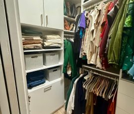 Custom walk-in closet with doors, drawers, laundry hamper, corner shelves, nickel hardware in Bartow, Florida.