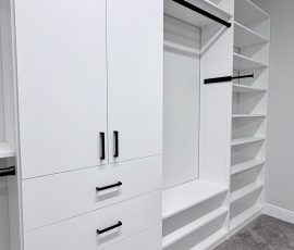 Custom walk-in closet with doors, drawers, corner shelves, black hardware in Lithia, Florida.
