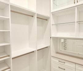 Custom walk-in closet with doors, drawers, glass, jewelry / accessory tray, matte colors, shoe fence, thermofoil, gold hardware in Zephyrhills, Florida.