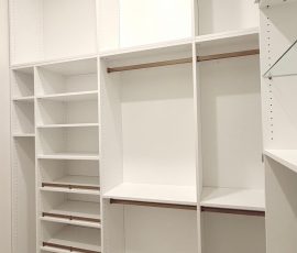 Custom walk-in closet with doors, drawers, glass, jewelry / accessory tray, matte colors, shoe fence, thermofoil, gold hardware in Zephyrhills, Florida.